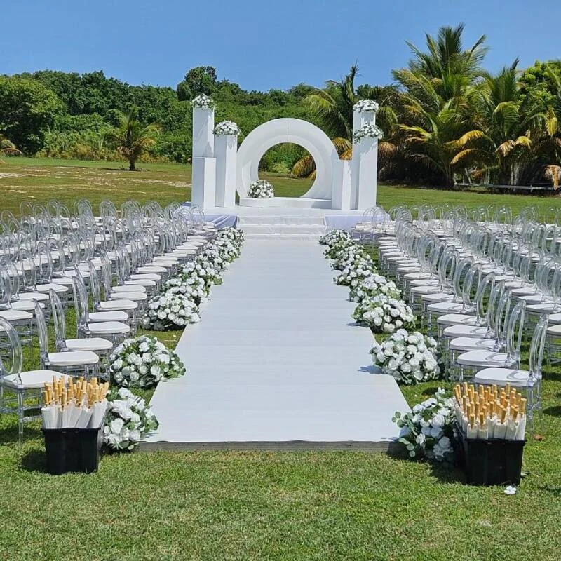Allée de cérémonie avec chaises et arche blanches dans le jardin Events du Levant